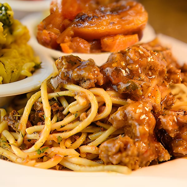 Mikki's Soul Food Cafe's spaghetti with meat sauce, candied yams, and mac and cheese.