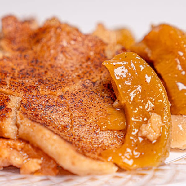 Close-up of golden-brown Mikki's Soul Food Cafe French toast topped with glistening caramelized apples.